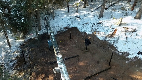 Work on a construction site during winter. Clip. Industrial background outdoors in winter forest. photo