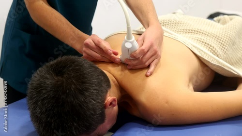 Anonymous physical therapy session with ultrasound treatment on back