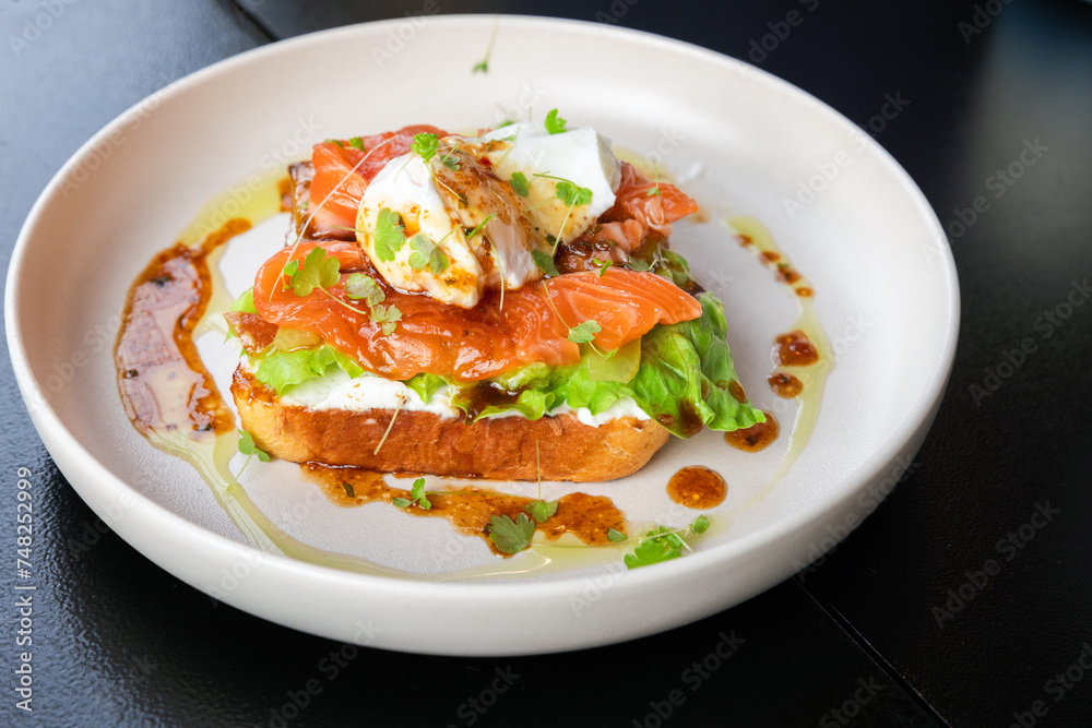 Sandwich with salmon and poached egg, close up photo Sandwich with salmon and poached egg, close up photo