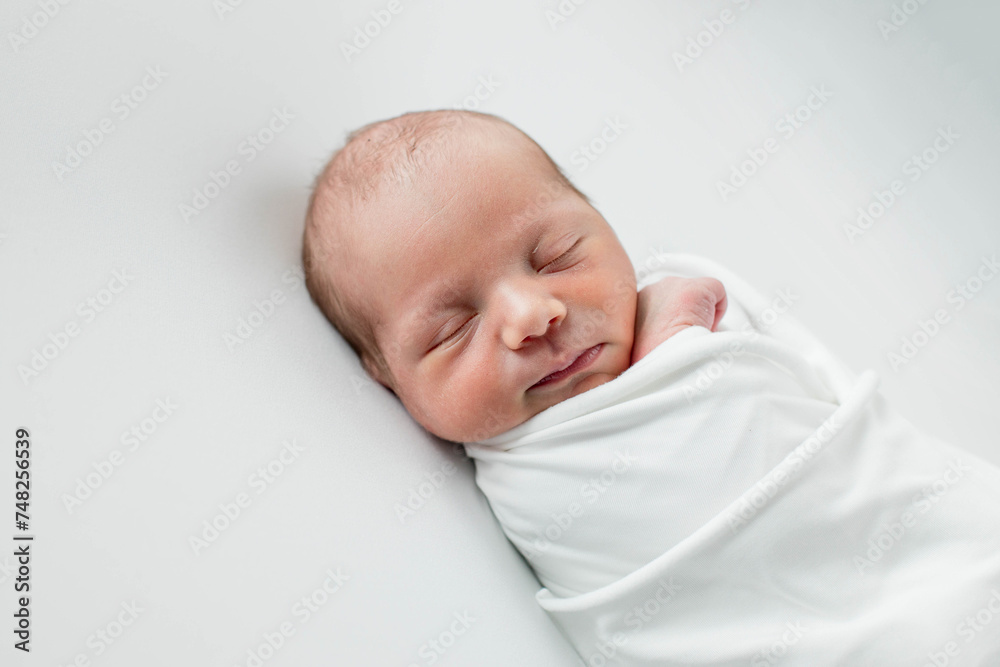 Close up of cute newborn baby sleeping on white background covered.Care,love,happiness concept. Close up of cute newborn baby sleeping on white background covered.Care,love,happiness concept.
