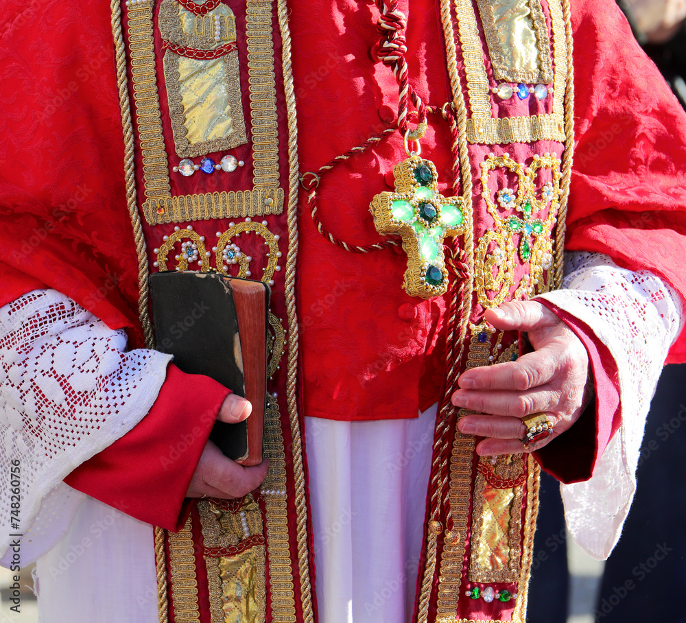 Priest in a Ceremonious Cassock Blessing with Bible in Hand