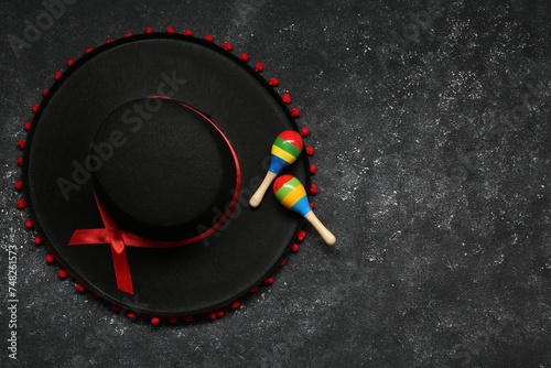 Mexican sombrero hat and maracas on grey textured background, flat lay. Space for text