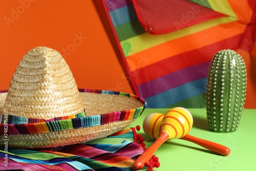 Composition with Mexican sombrero hat and maracas on green table  closeup