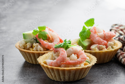 Shrimp and cheese salad tartlets appetizer on gray background © lena_zajchikova