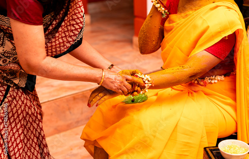 Haldi ceremony is an Indian pre-wedding ritual where turmeric paste is smeared on the bride's body by family and friends