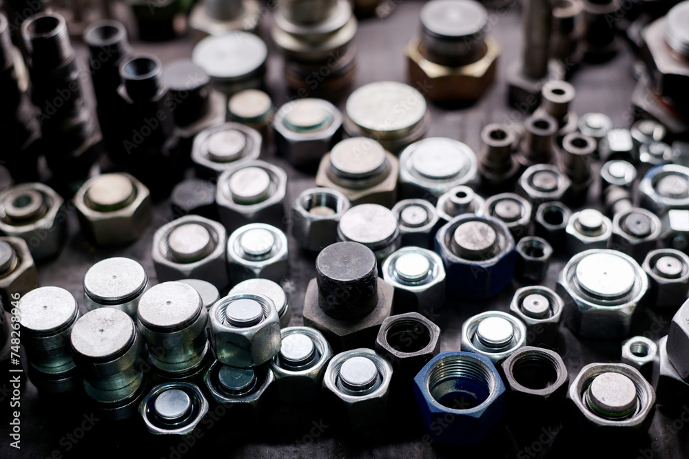 Closeup still life of metal hex nuts and bolts on table, industrial background Closeup still life of metal hex nuts and bolts on table, industrial background