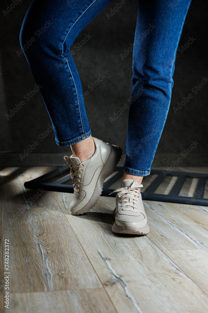 Beige women's sneakers. Collection of women's leather shoes. Female legs in leather beige casual sneakers. Stylish women's sneakers. Beige women's sneakers. Collection of women's leather shoes. Female legs in leather beige casual sneakers. Stylish women's sneakers.