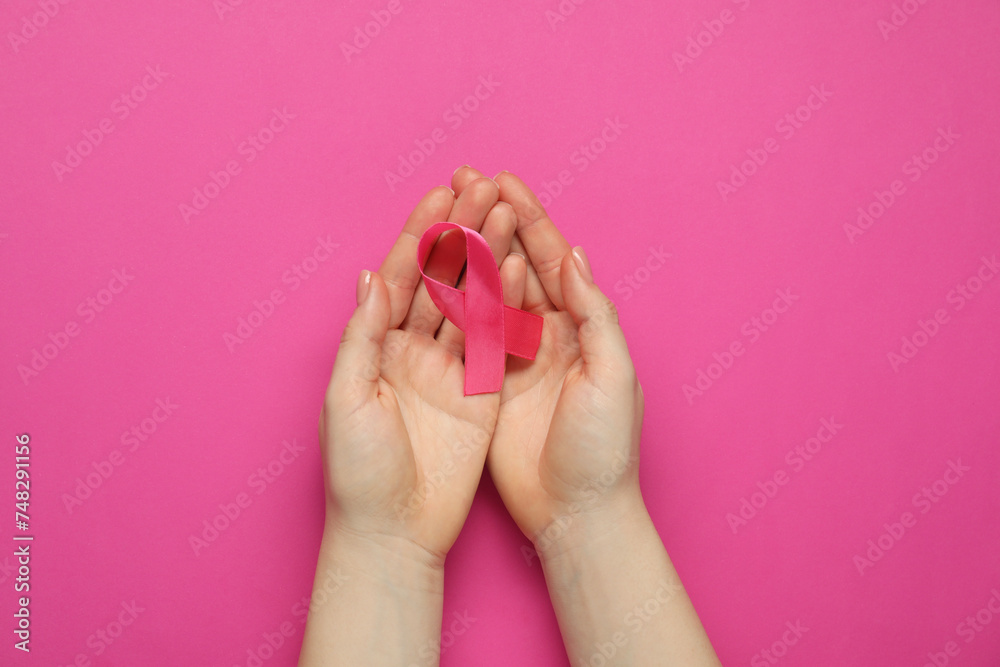 Woman with pink ribbon on color background, top view. Breast cancer awareness Woman with pink ribbon on color background, top view. Breast cancer awareness