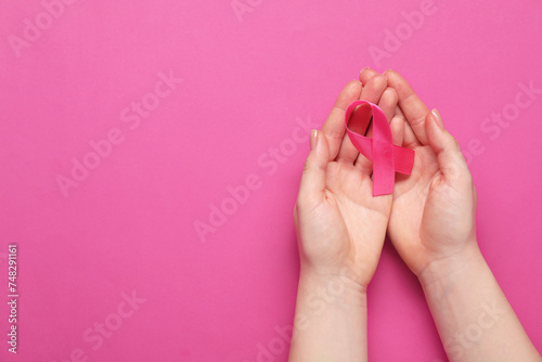 Breast cancer awareness. Woman with pink ribbon on color background  top view. Space for text