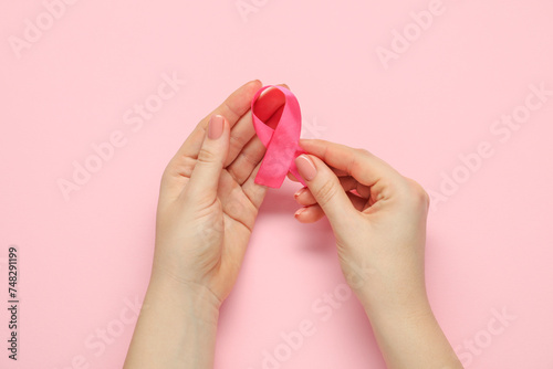 Woman with pink ribbon on color background, top view. Breast cancer awareness