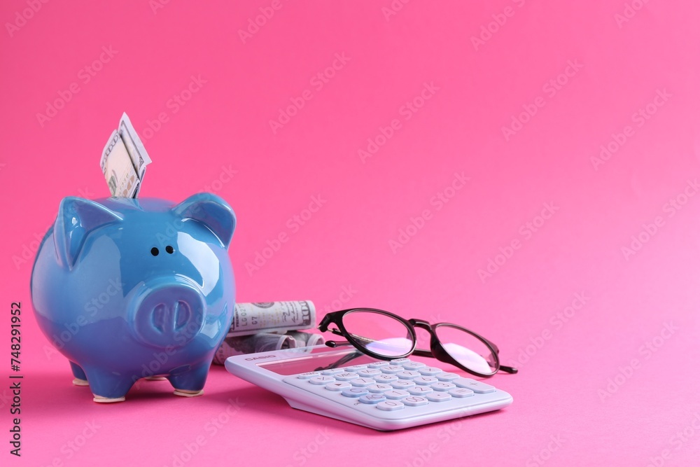 Financial savings. Piggy bank, dollar banknotes, glasses and calculator on pink background - obrazy, fototapety, plakaty 