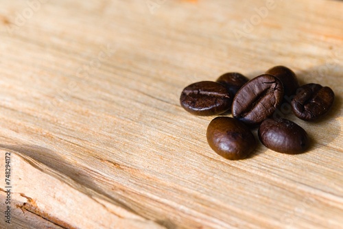 Coffee beans arranged on a piece of raw, freshly split wood.