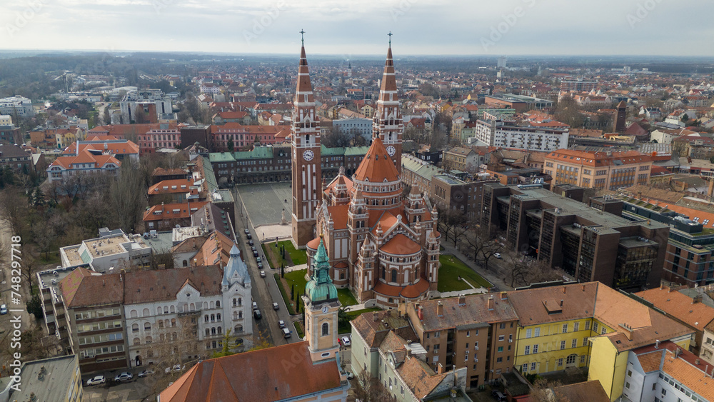 Obraz premium Drone footage from downtown of Szeged, Hungary on a sunny winter day. Szeged, Drone, Aerial, Hungary, Urban Landscape, Szeged Cathedral, Tisza River, Bridge