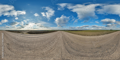 hdri 360 panorama on gravel road among fields in spring evening with awesome clouds in equirectangular full seamless spherical projection, for VR AR virtual reality content