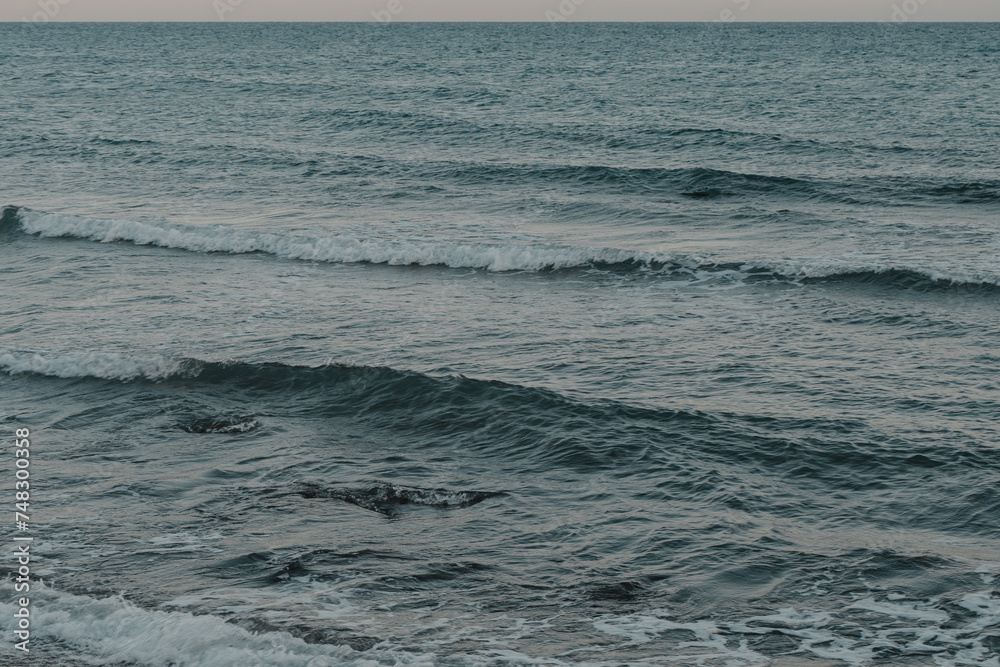 blue calm waves on the sea during sunset