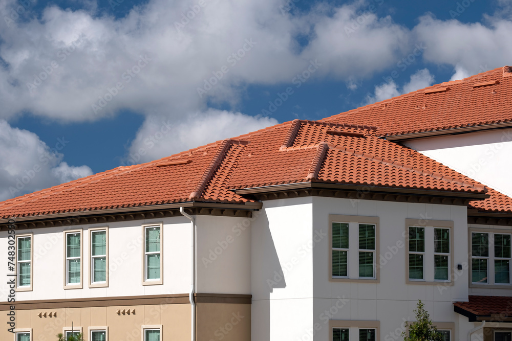 Tiled roof covering of condo building in Florida. Closeup of house rooftop covered with ceramic shingles