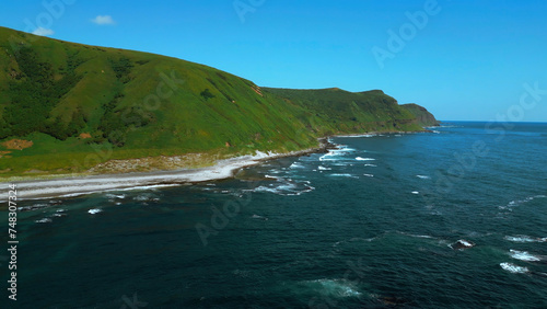 Breathtaking aerial view of the summer beach coastline. Clip. Wild empty sea shore and green fields. photo