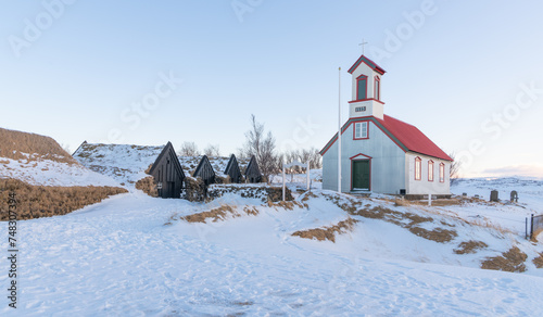 Beautiful old church near Keldur turf house farm, in the south of Iceland during winter. Catholic church in iceland with snowy landscape in the backgroundwith soft afternoon light. Travel destination.