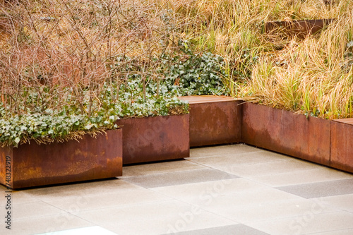 Green plants in corten flower pots.