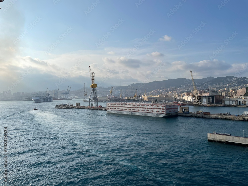 wide panoramic view of the harbor of Genoa. Blue sky blue sea white clouds and port buildings in harmony with the surrounding Mediterranean landscape