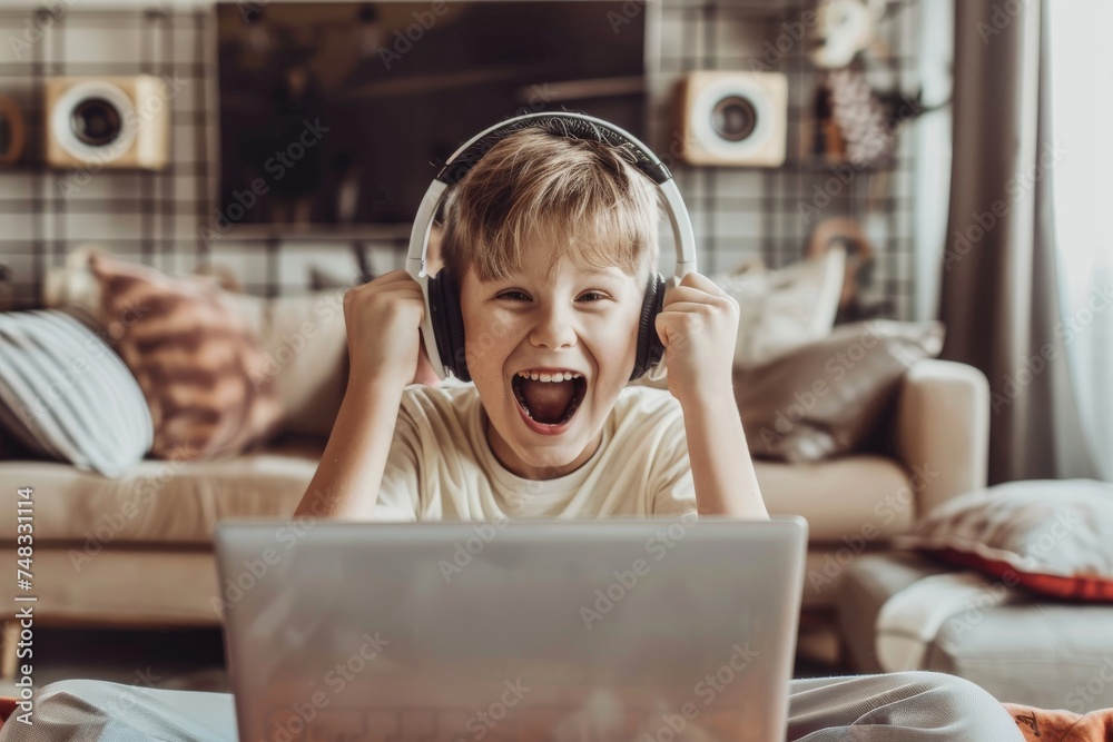 An enthusiastic young boy with headphones is using a laptop, with an open mouth expression of excitement An enthusiastic young boy with headphones is using a laptop, with an open mouth expression of excitement