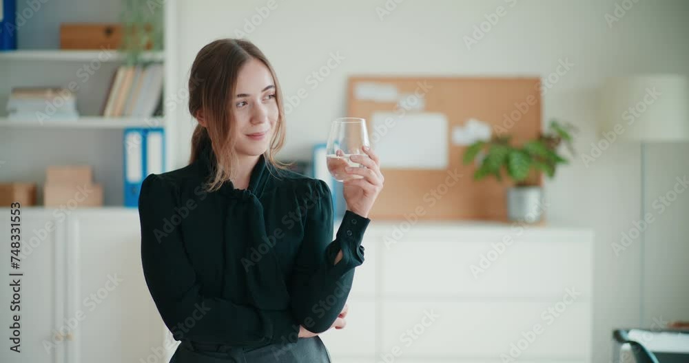Smiling young businesswoman holding glass of water Smiling young businesswoman holding glass of water