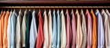 A collection of mens shirts in various colors and styles hanging neatly on a clothing rack. The shirts are displayed for easy access and organization.
