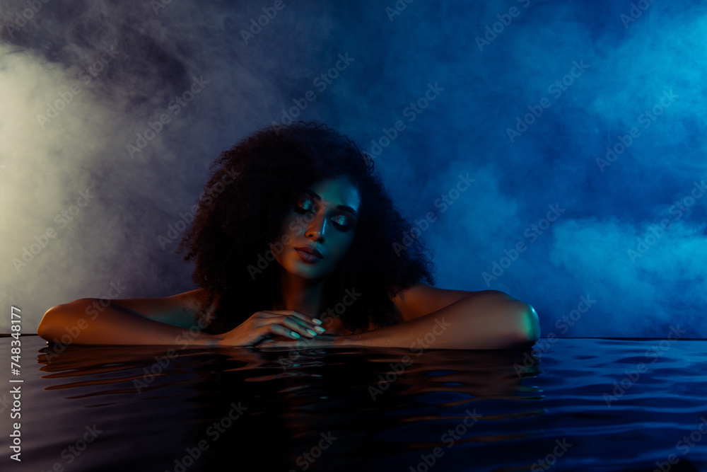 Portrait of chic luxurious lady enjoy hotel holiday spa procedure in blue ultraviolet bath over dark background