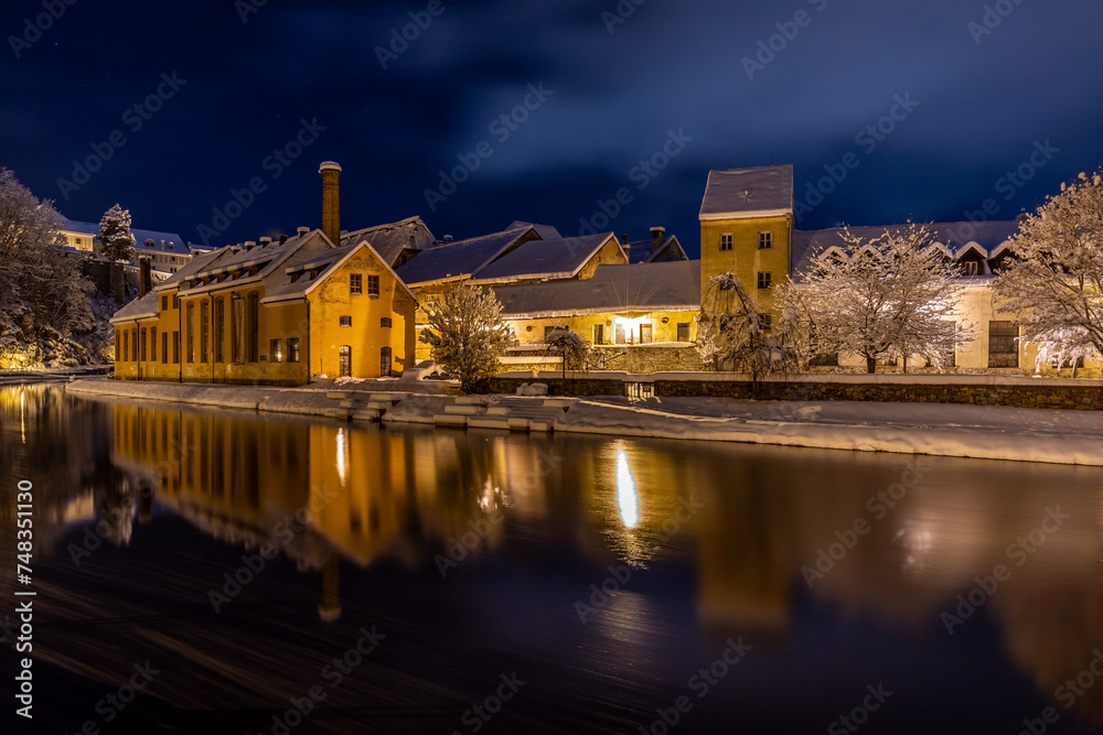 Winter view of Cesky Krumlov, picturesque houses under the castle with snow-covered roofs. Narrow streets and the Vltava river. Travel and Holiday in Europe. UNESCO World Heritage. Czechia