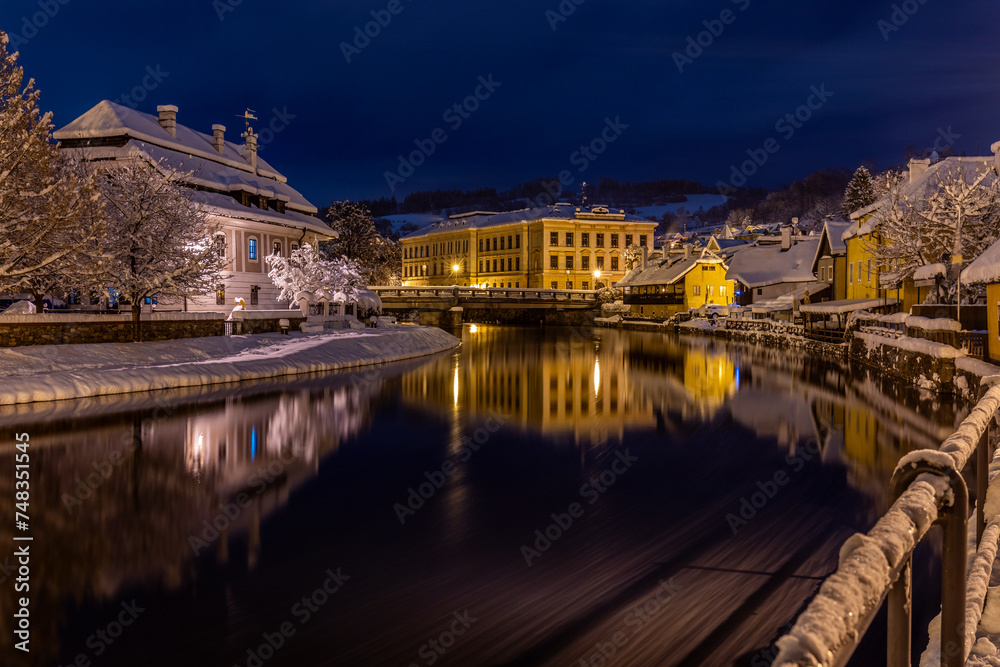 View of Czech Krumlov in winter, Czech Republic. Picturesque houses under the castle with snow-covered roofs. Narrow streets and the Vltava river. Travel and Holiday in Europe. UNESCO World Heritage.
