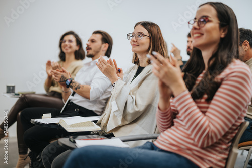 Fotografie Group of attentive professionals applauding after a successful presentation at a business conference, showing satisfaction and engagement