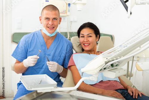 Woman is sitting satisfied in chair after treatment in dental office
