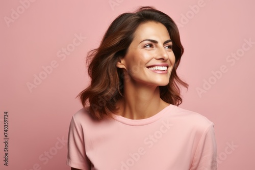 Portrait of young happy smiling woman looking up, over pink background