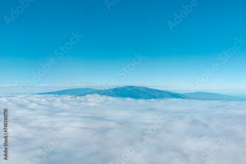 Aerial photography of Honolulu to Hilo from the plane. From left to right: Mauna Kea, Mauna Loa, and Hualalai. Hawaii island 
