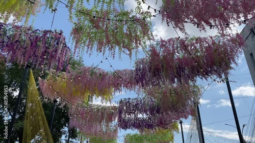 Festival garlands flowers above are blowing in the wind over the pedestrian street. Decorations of the city square for the holiday.