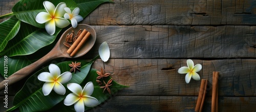 A wooden spoon is adorned with cinnamon sticks and delicate flowers  set against a backdrop of aged wood. The green plant and fragrant cinnamon add a touch of natural beauty to the scene.