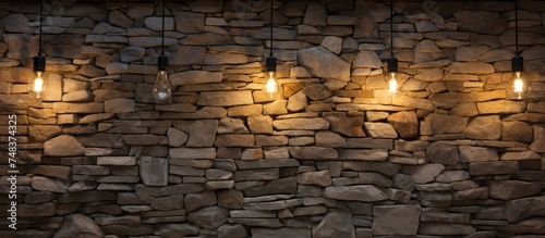 A modern stone wall adorned with three sleek lights, adding a contemporary touch to the interior design. The lights cast a warm glow, enhancing the ambiance of the space.