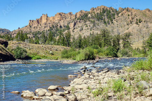 North Fork Shoshone River, stoney bank, canyon and blue-sky summer season landscape of northwest Wyoming, USA. 