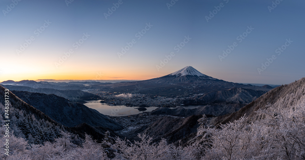 Panoramic view of snow-capped Mt. Fuji with snow trees early in the morning. Panoramic view of snow-capped Mt. Fuji with snow trees early in the morning.