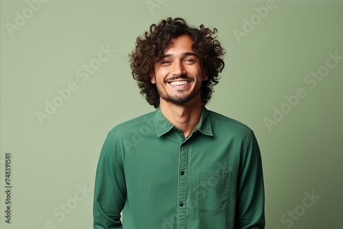 Portrait of a handsome young man with curly hair against green background