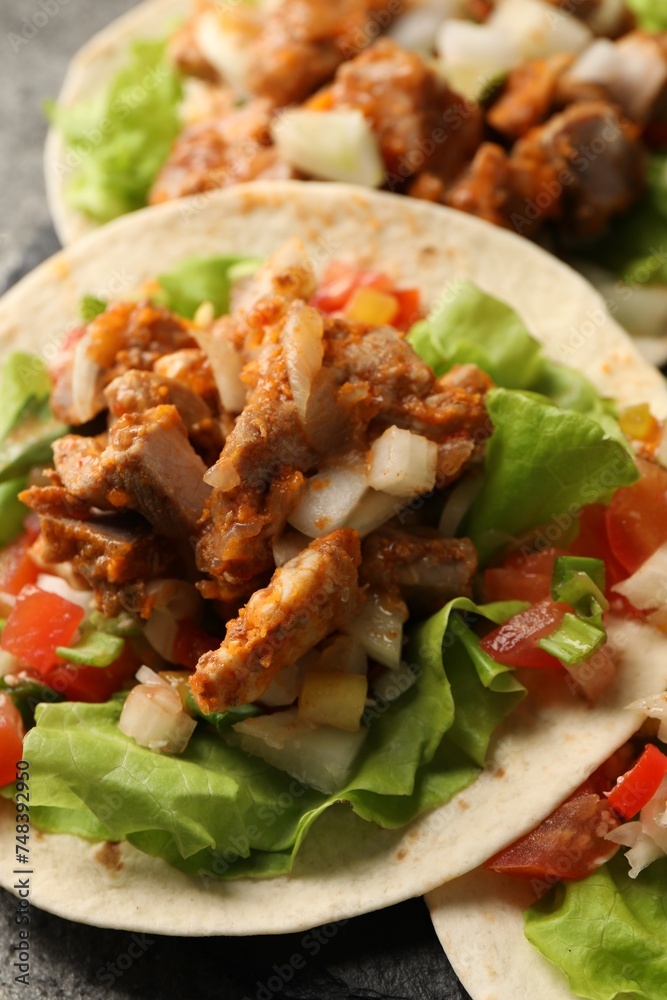 Delicious tacos with vegetables and meat on grey table, closeup Delicious tacos with vegetables and meat on grey table, closeup