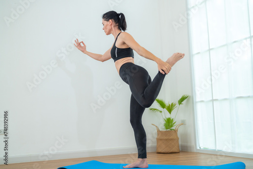 Two women confident training yoga. Athletic women in sportswear doing fitness stretching exercises at home in the living room. Sport and recreation concept. Yoga teacher is helping young woman.