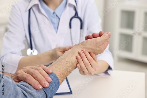 Arthritis symptoms. Doctor examining patient's wrist in hospital, closeup photo