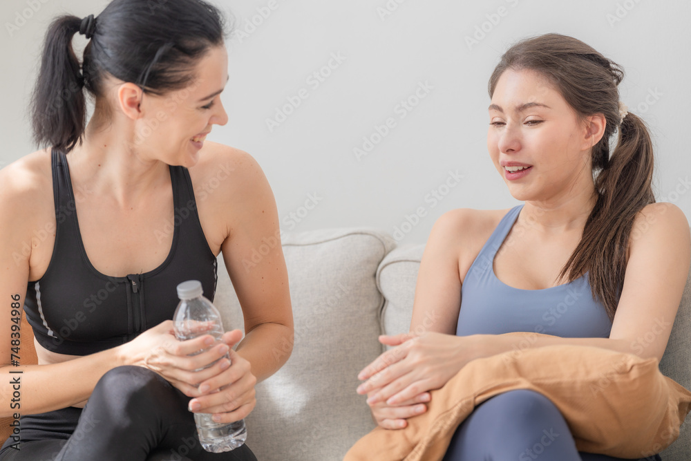 Group of happy sporty women wearing body stylish sportswear and talking together. waiting for yoga class.. healthy lifestyle and wellness. Couple women are relaxing and sitting at sofa in living room. Group of happy sporty women wearing body stylish sportswear and talking together. waiting for yoga class.. healthy lifestyle and wellness. Couple women are relaxing and sitting at sofa in living room.
