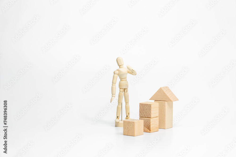 Wooden doll with wooden toy block isolated on white background. business or creative concept Wooden doll with wooden toy block isolated on white background. business or creative concept