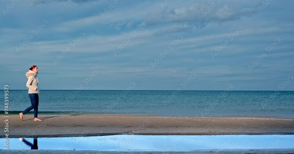 A young girl walking barefoot along a serene coastline, illuminated by the gentle rays of the sun. With the soft texture of the sand and the tranquil sounds of the sea A young girl walking barefoot along a serene coastline, illuminated by the gentle rays of the sun. With the soft texture of the sand and the tranquil sounds of the sea
