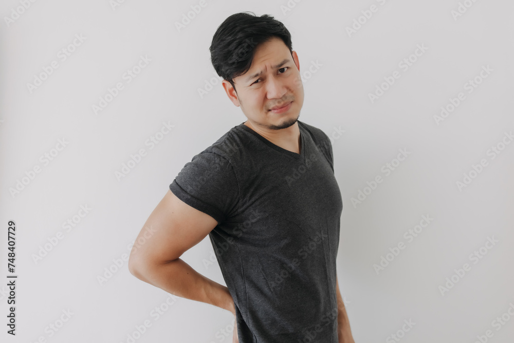 Asian man in black t-shirt feeling sick and hurt of back pain isolated on white wall. Asian man in black t-shirt feeling sick and hurt of back pain isolated on white wall.