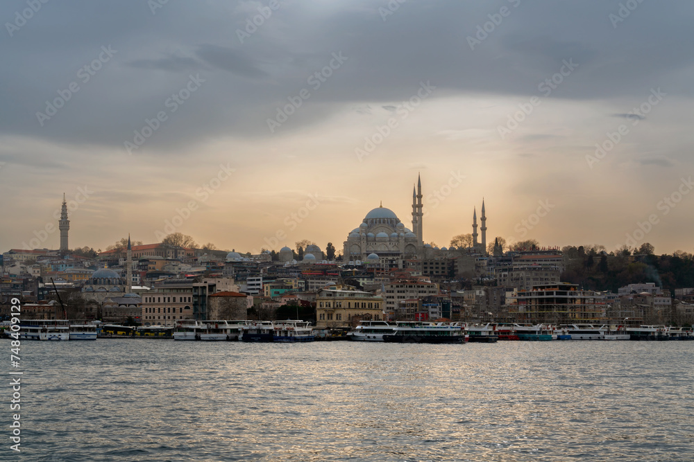 View of the Fatih district in Istanbul from the waters of the Golden Horn Bay and the Suleymaniye Mosque against the sunset sky, Istanbul, Turkey