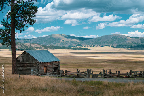 Fotografía Old barn and corral sit on edge of large mountain meadow