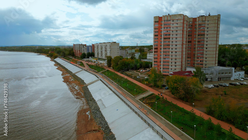 Aerial drone view of city river embankment. Clip. Urban cityscape with walking people. photo